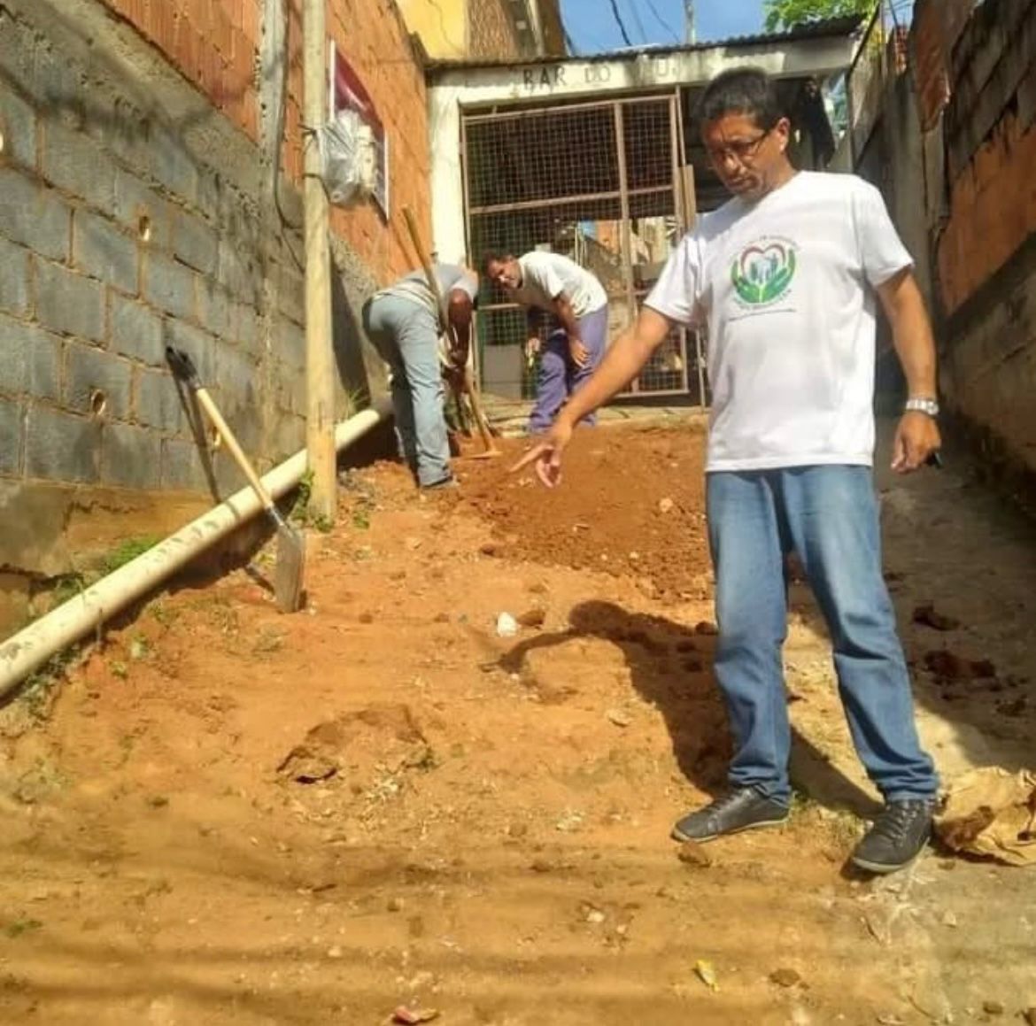 Moradores em conjunto com a liderança comunitária realizam reparos em via precária, demonstrando protagonismo popular diante da ausência do poder público.